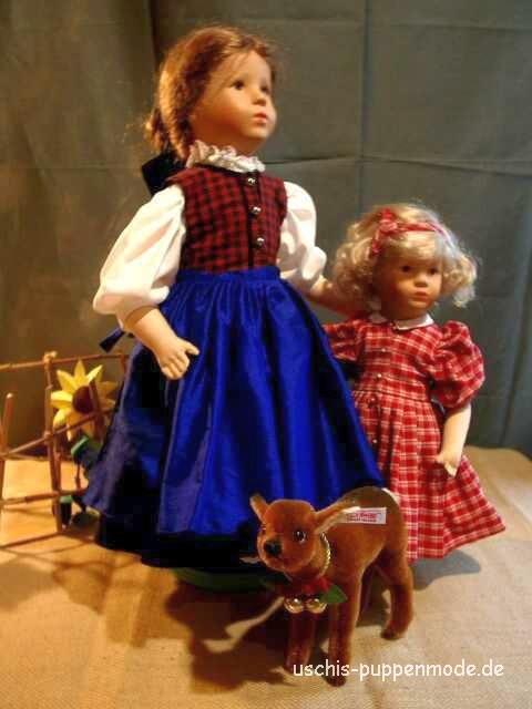 Ein Puppendirndl mit rotkariertem
                              Leibchen und ein rotkariertes
                              Puppenkleid.
